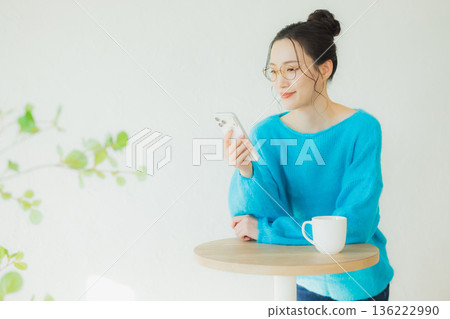 A woman watching a smartphone A woman watching a smartphone 136222990
