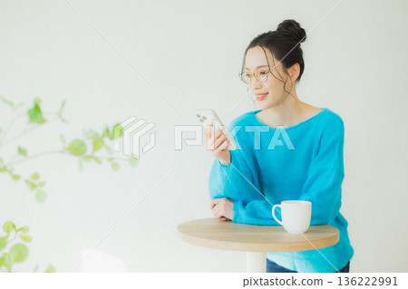 A woman watching a smartphone A woman watching a smartphone 136222991