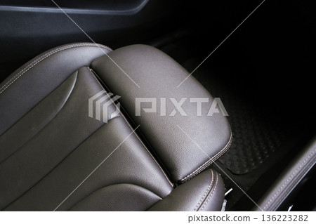 A close-up of a premium brown leather car seat with car leg rest 136223282