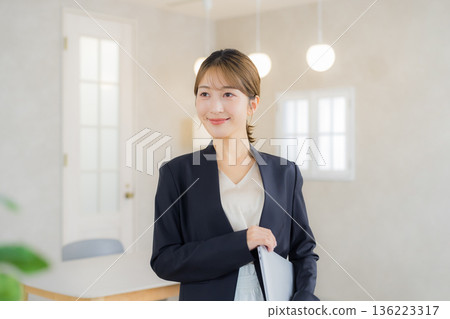 A woman in a suit with a file A woman in a suit with a file 136223317