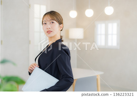 A woman in a suit with a file 136223321