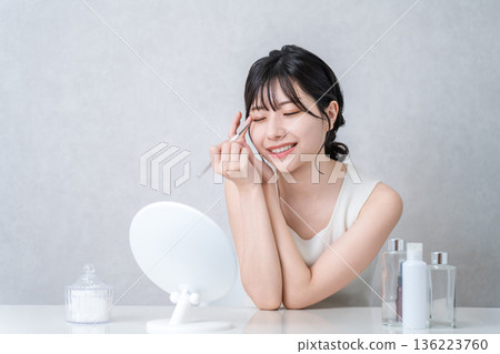Young Asian woman applying eyeshadow while applying makeup Young Asian woman applying eyeshadow while applying makeup 136223760