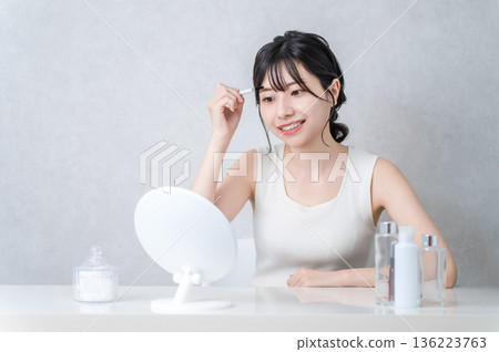 Young Asian woman applying makeup at home (eyebrows, eyebrows, makeup) 136223763