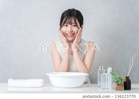 Young Asian woman washing her face and doing skin care at home Young Asian woman washing her face and doing skin care at home 136223770