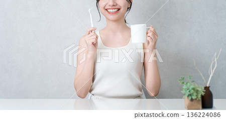 Young Asian woman brushing her teeth (toothpaste, oral care, dental care) Young Asian woman brushing her teeth (toothpaste, oral care, dental care) 136224086
