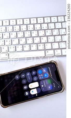 Smartphone Control Center Displayed Above Keyboard, Quick Settings For Audio And Connectivity During Remote Consultation, Tidy White Desk With Focus On Connection 136224260
