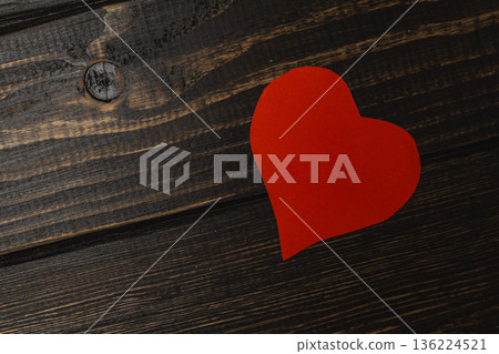 Heart shape cut from paper placed on wooden surface Heart shape cut from paper placed on wooden surface 136224521