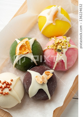 Colorful sweet treats displayed on a wooden board with simple decoration Colorful sweet treats displayed on a wooden board with simple decoration 136224632