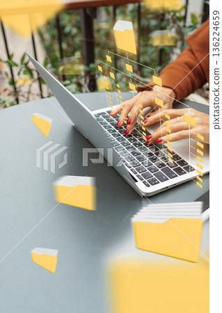 Working on a laptop with floating file icons in a modern workspace 136224659