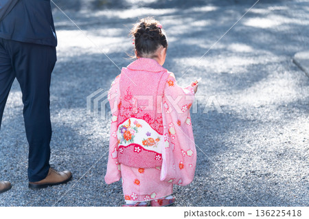 A girl walking through a shrine during a Shichi-Go-San celebration A girl walking through a shrine during a Shichi-Go-San celebration 136225418