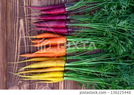 Colorful carrots Rainbow mix on the brown wooden table. Colorful carrots Rainbow mix on the brown wooden table. 136225448