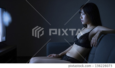 A Japanese woman in black underwear watching TV in a dark room A Japanese woman in black underwear watching TV in a dark room 136226073