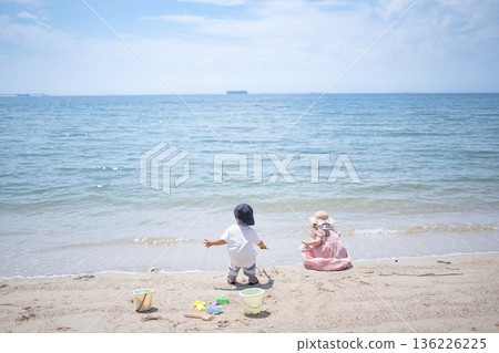 Sister and brother playing in the sand at the beach 136226225