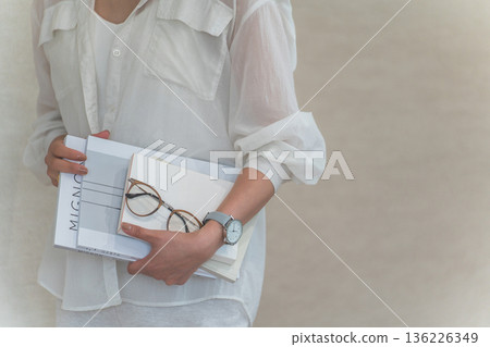 A stylish woman holding a magazine or book A stylish woman holding a magazine or book 136226349