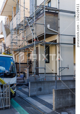 為房屋外牆粉刷工作搭建的鷹架和材料卡車 為房屋外牆粉刷工作搭建的鷹架和材料卡車 136226411