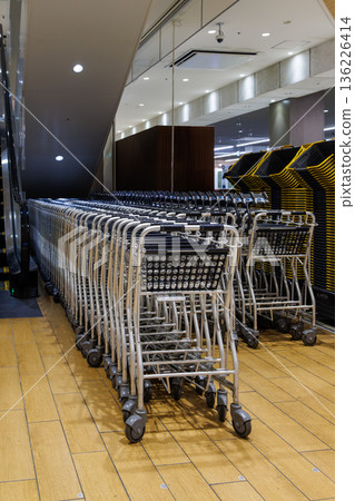 Shopping carts and baskets lined up in a supermarket Shopping carts and baskets lined up in a supermarket 136226414