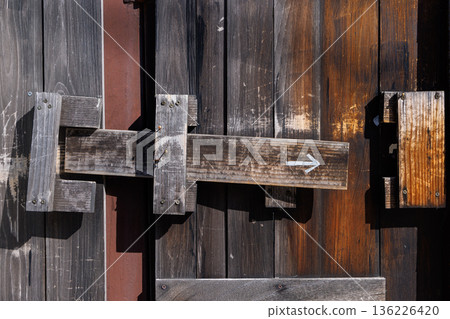 古老的木門鎖，上面畫著箭頭，紋理清晰可見。 136226420