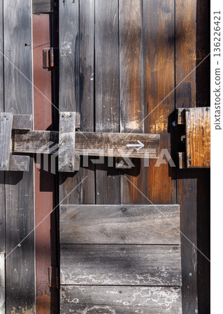 古老的木門鎖，上面畫著箭頭，紋理清晰可見。 136226421