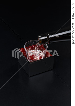 Mokkiri sake poured into a masu on a black background Mokkiri sake poured into a masu on a black background 136226518