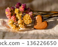 Wooden heart with dried flowers on textured fabric background 136226650