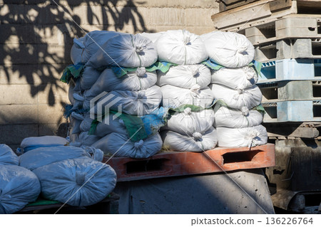 Pallet-stacked sandbags with sunlight filtering through the trees Pallet-stacked sandbags with sunlight filtering through the trees 136226764