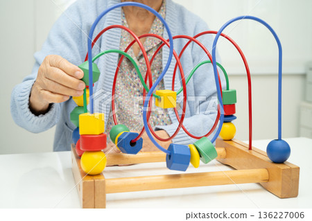 Asian elderly woman playing enhancing skill board game. Asian elderly woman playing enhancing skill board game. 136227006