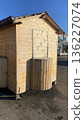 A small wooden booth or kiosk with a curved outdoor counter, closed and unstaffed, in an open paved area.  136227074