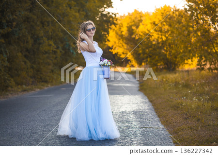 bride with a bouquet is walking the green park bride with a bouquet is walking the green park 136227342