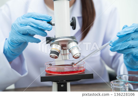Scientist medical professional use microscope for research in science laboratory. 136228106