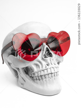 Human Skull with Red Heart Shaped Sunglasses Side View on White Background Human Skull with Red Heart Shaped Sunglasses Side View on White Background 136228829