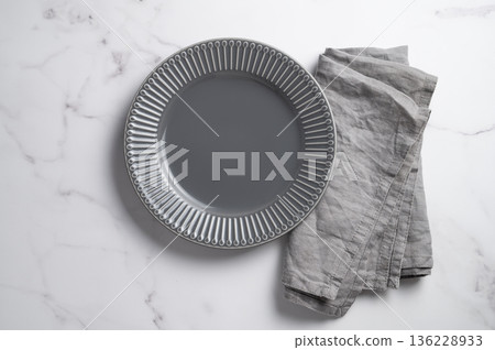 A ceramic dark gray plate with a linen napkin  on a marble  background. 136228933