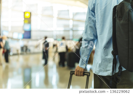 A man carrying luggage at the airport. Photo courtesy of Kansai International Airport (KIX). 136229062