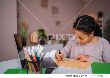 Young girl drawing on paper with markers at home Young girl drawing on paper with markers at home 136229205