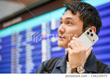 一名男子在機場打電話。照片由關西國際機場(KIX)提供。 一名男子在機場打電話。照片由關西國際機場(KIX)提供。 136229475