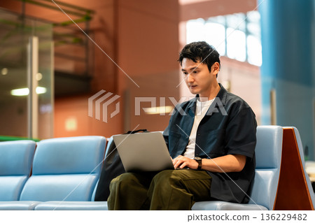 A man working on a PC at the airport. Photo courtesy of Kansai International Airport (KIX). 136229482