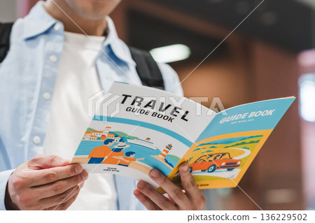 一名男子正在閱讀旅遊指南。照片由關西國際機場(KIX)提供。 一名男子正在閱讀旅遊指南。照片由關西國際機場(KIX)提供。 136229502