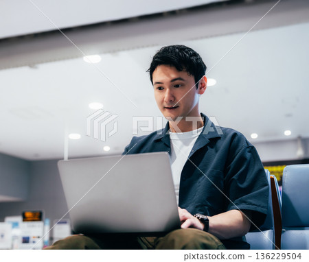A man working on a PC at the airport. Photo courtesy of Kansai International Airport (KIX). 136229504