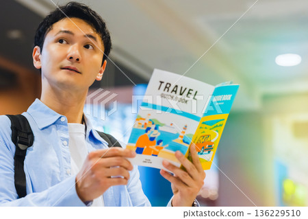 A man reading a guidebook at the airport. Photo courtesy of Kansai International Airport (KIX). A man reading a guidebook at the airport. Photo courtesy of Kansai International Airport (KIX). 136229510