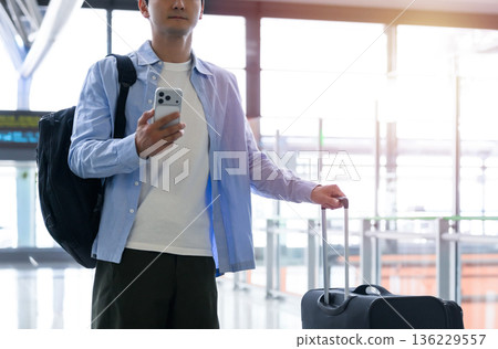 Traveler operating smartphone Traveler operating smartphone 136229557