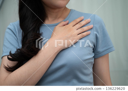 Asian woman self touching check lump or Breast cancer, Breast Self Exam. 136229620