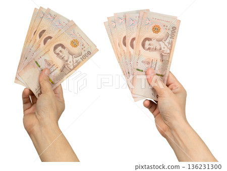 Asian woman holding Thai baht banknote money in hand isolated on white background. Asian woman holding Thai baht banknote money in hand isolated on white background. 136231300