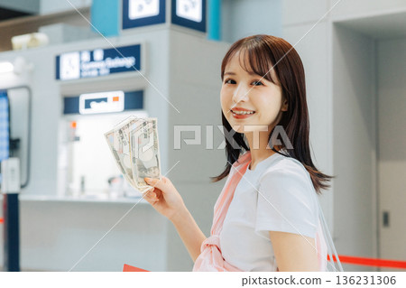 A woman exchanging money at the airport (Photo courtesy of Kansai International Airport (KIX)) 136231306