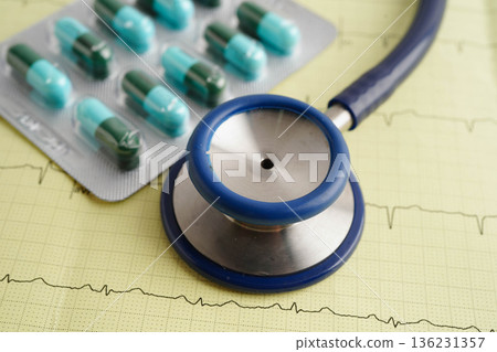 Stethoscope on electrocardiogram ECG with capsule drug, heart wave, heart attack, cardiogram report. Stethoscope on electrocardiogram ECG with capsule drug, heart wave, heart attack, cardiogram report. 136231357