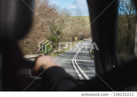 Rear passenger point of view from interior of car travelling, looking out the window on a country road - speed on single carriageway, trip concept 136232221