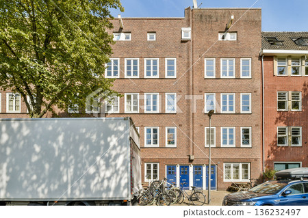 A modern urban building display features large windows and a brick facade with bicycles parked in front, embodying contemporary city life. A modern urban building display features large windows and a brick facade with bicycles parked in front, embodying contemporary city life. 136232497