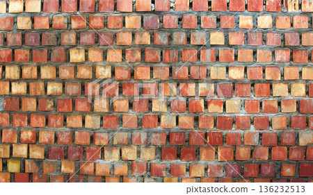 A rough orange brick wall recently made with fresh wet cement 136232513