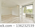 Spacious and airy room featuring natural light streaming in through large windows. The minimalist design emphasizes clean lines and comfort. 136232539