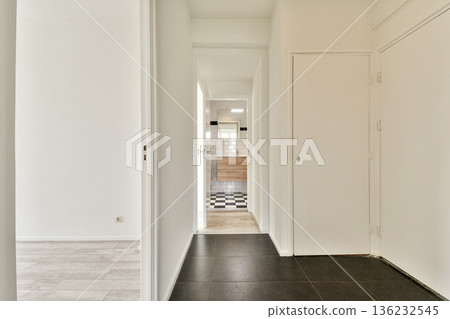 A sleek and modern hallway showcasing minimalist design elements. The space features a clear view into a stylish bathroom with clean lines and neutral colors. 136232545