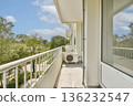 A serene balcony view showcasing natural greenery, blue skies, and a peaceful atmosphere. Perfect for relaxation and enjoying outdoor tranquility. 136232547