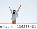 Woman Arms Beach: Woman raising arms toward clear sky, celebrating on sunny summer beach by sparkling sea. 136233481